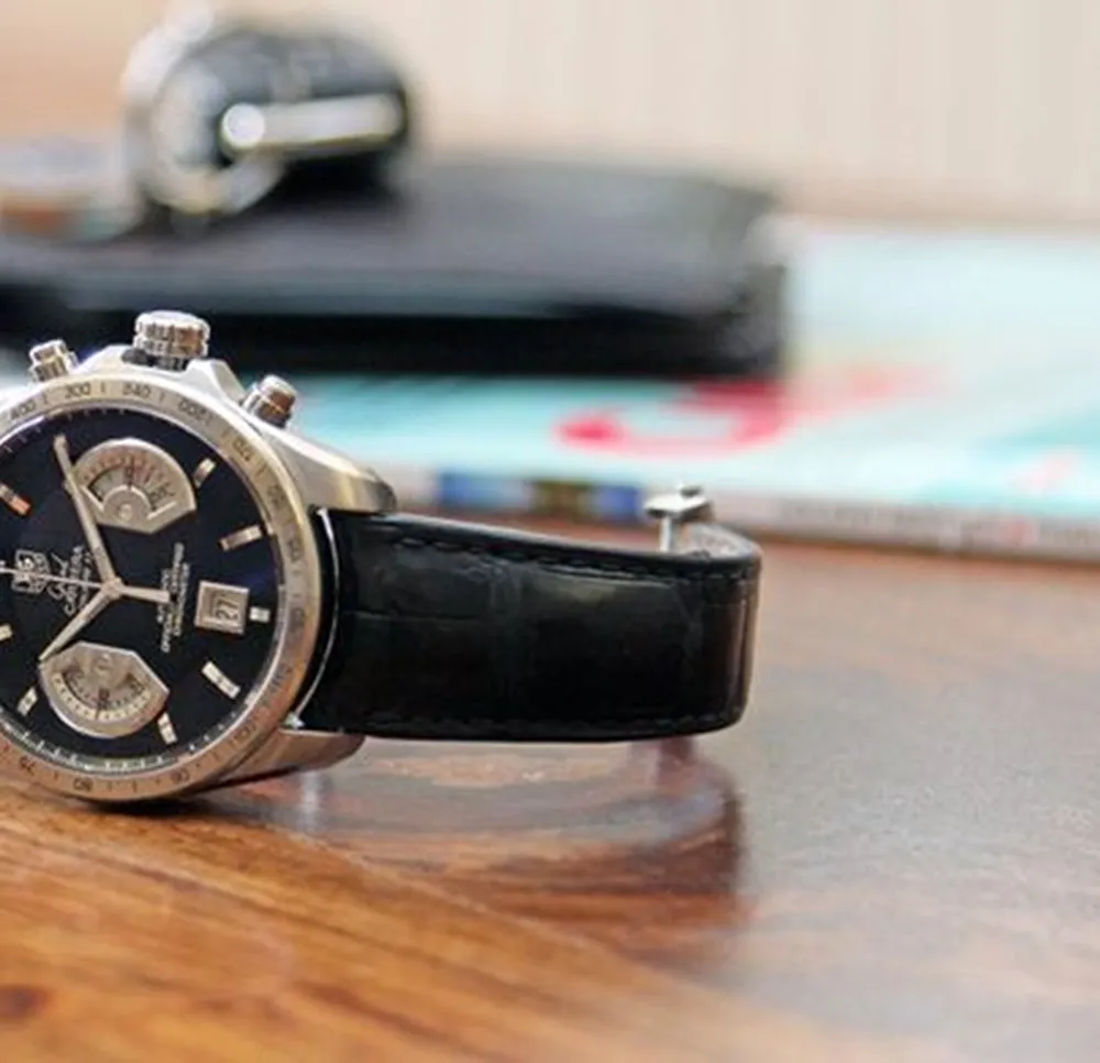 Photograph of a watch on a varnished wooden tabletop