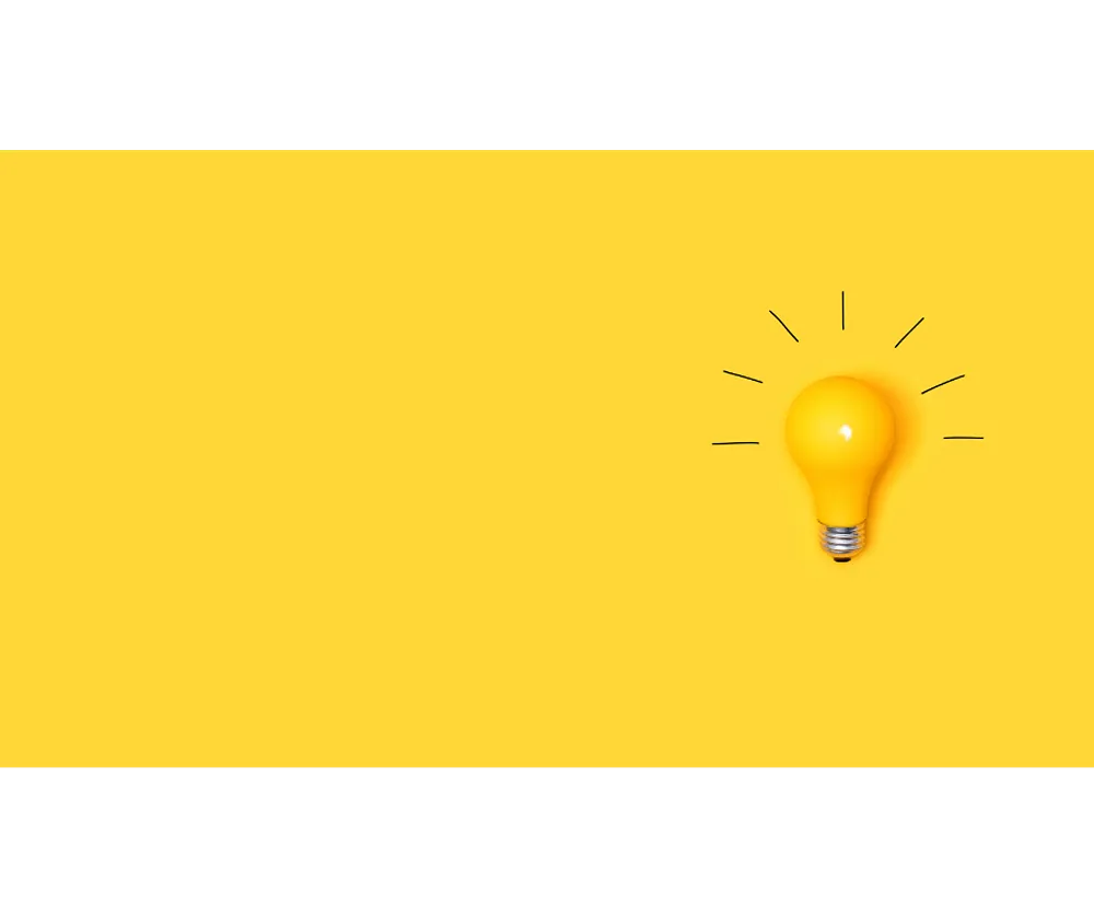 A yellow lightbulb with an illustration of light rays around it on a yellow background