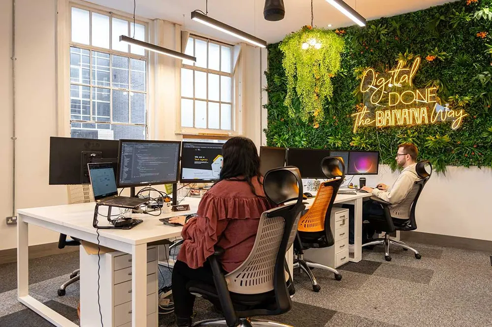 CB HQ downstairs office space with two developers working at their desks.
