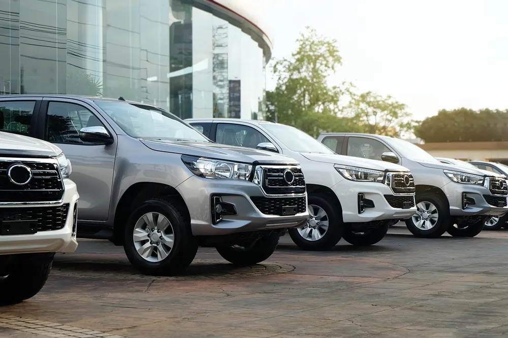 Silver and white pickup trucks in a car dealership.