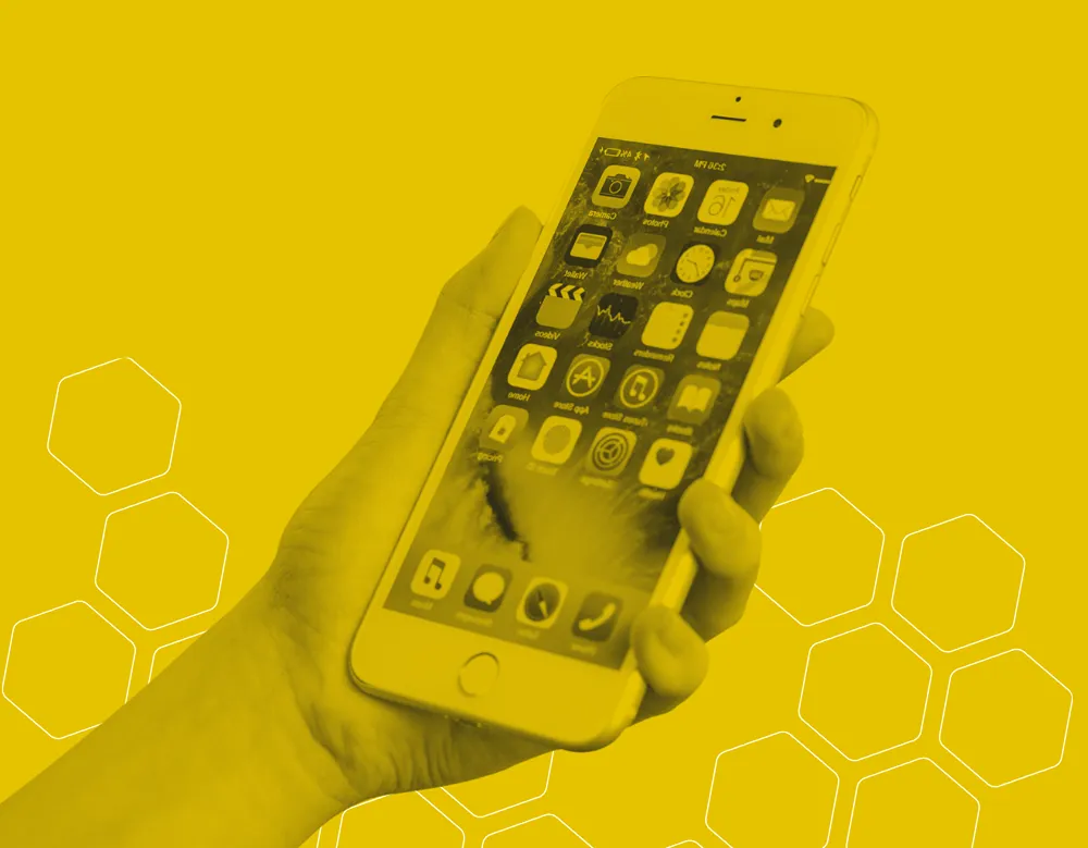 A yellow and black graphic of a persons hand holding a smartphone device with a grid of applications shown