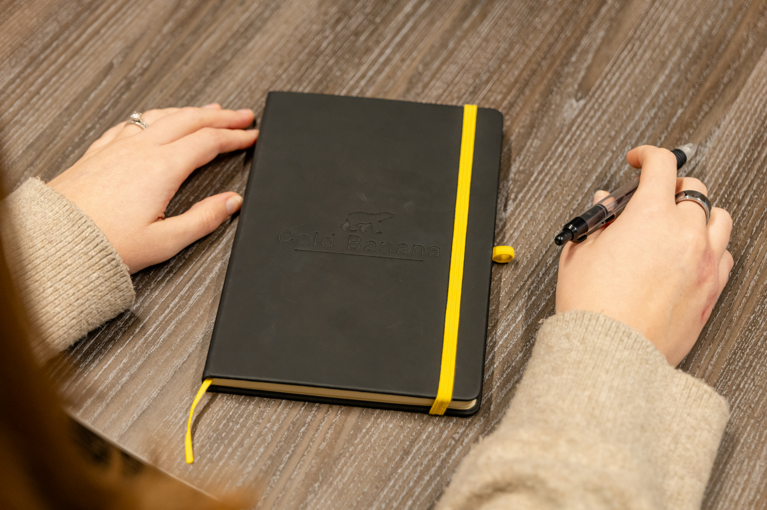 A Cold Banana employee with their branded notebook and pen