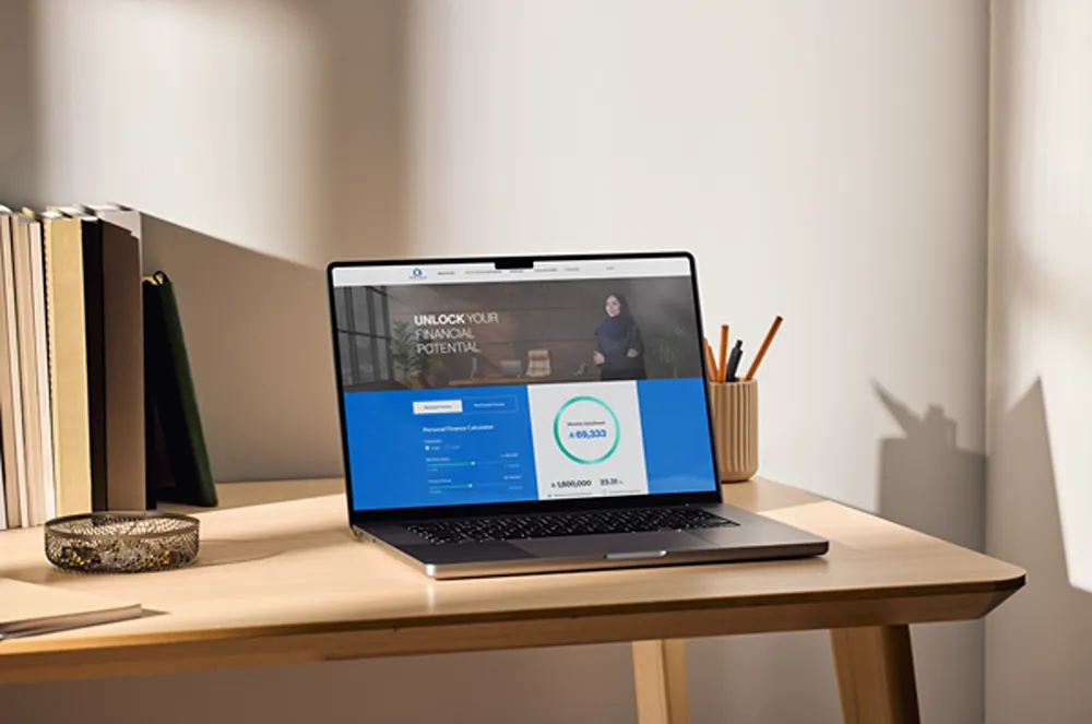 Amlak International webpage open on a desktop monitor on the desk of a home office