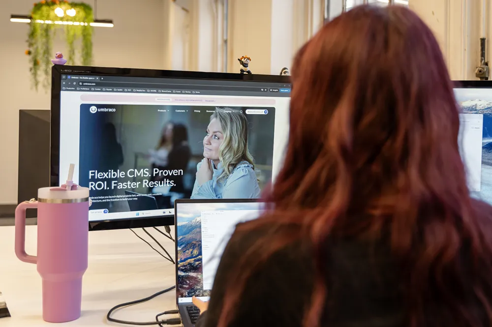 A Cold Banana employee with the Umbraco homepage open on their desktop monitor