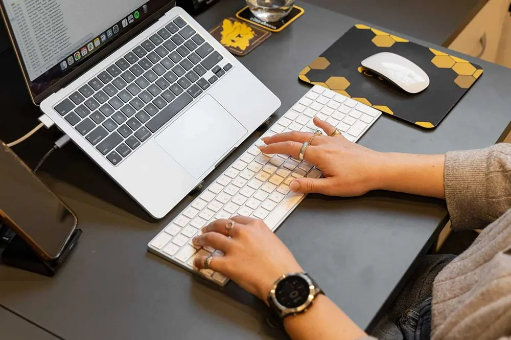A Cold Banana employee typing at their desk.