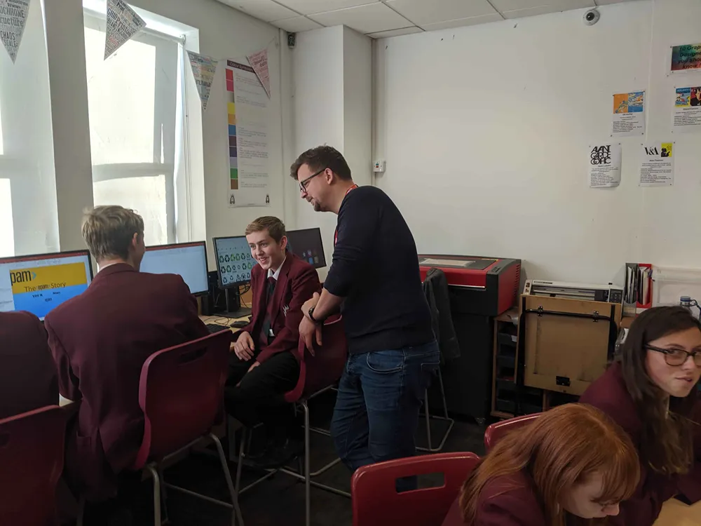 BIMA Digital Day students working in a classroom as a Cold Banana team member assists.