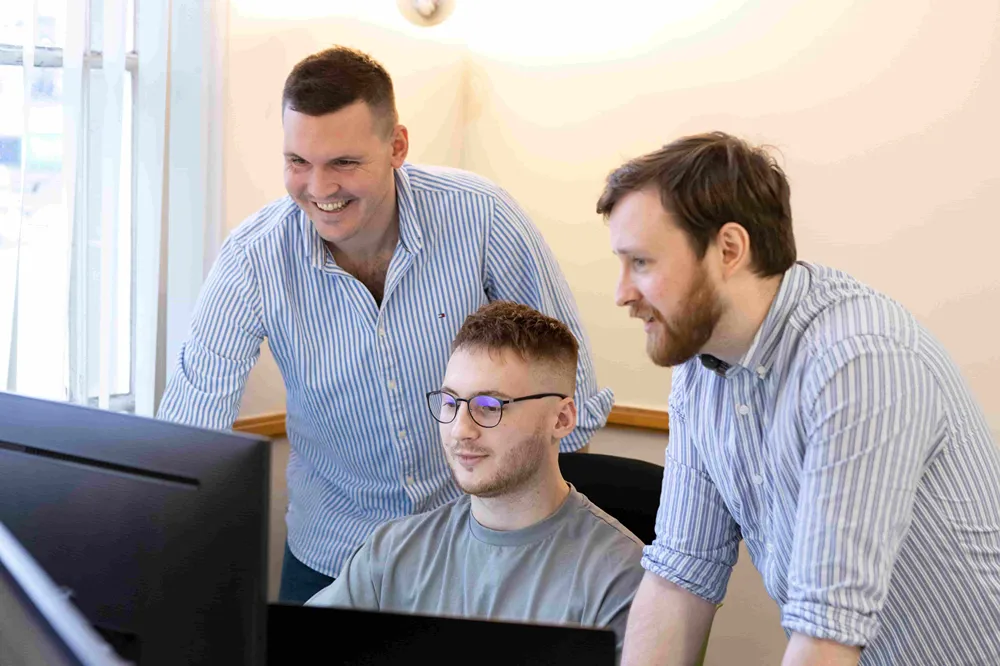 Three Cold Banana employees working together on a problem.