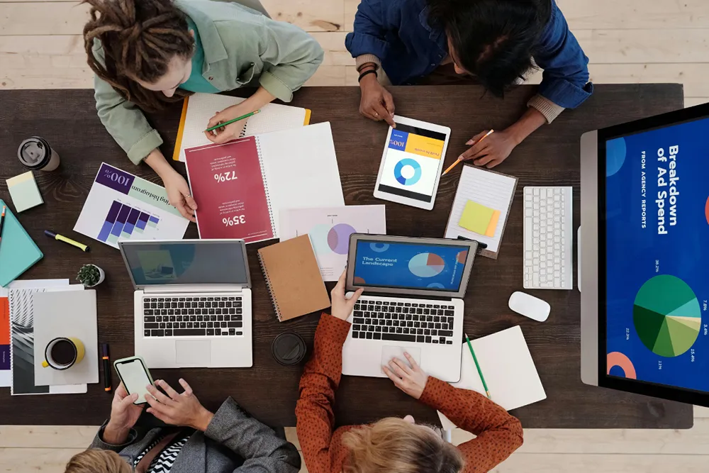 A team of four people working on a slide deck.