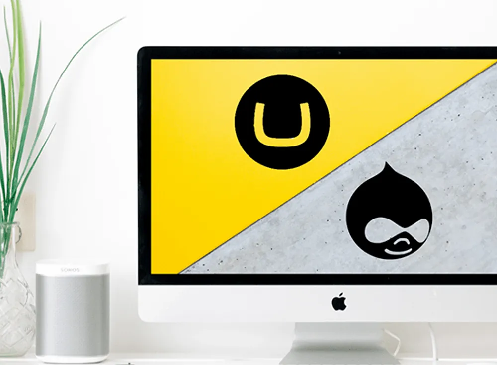 Umbraco and Drupal logos on an Apple computer desktop monitor in a home officer