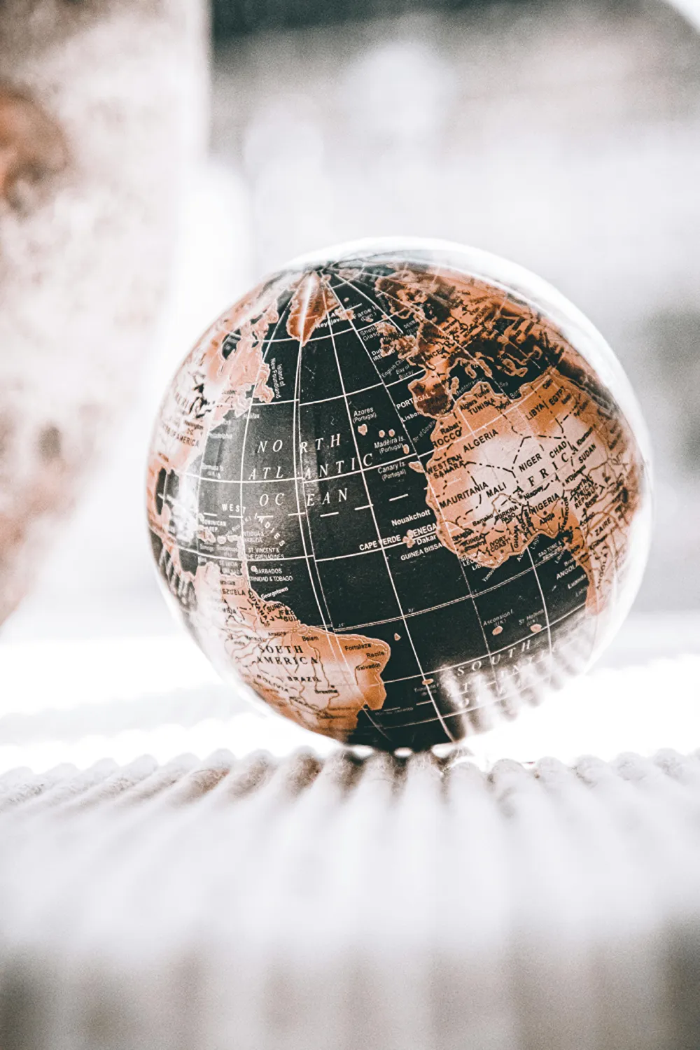 A black and brown globe on a cream carpet