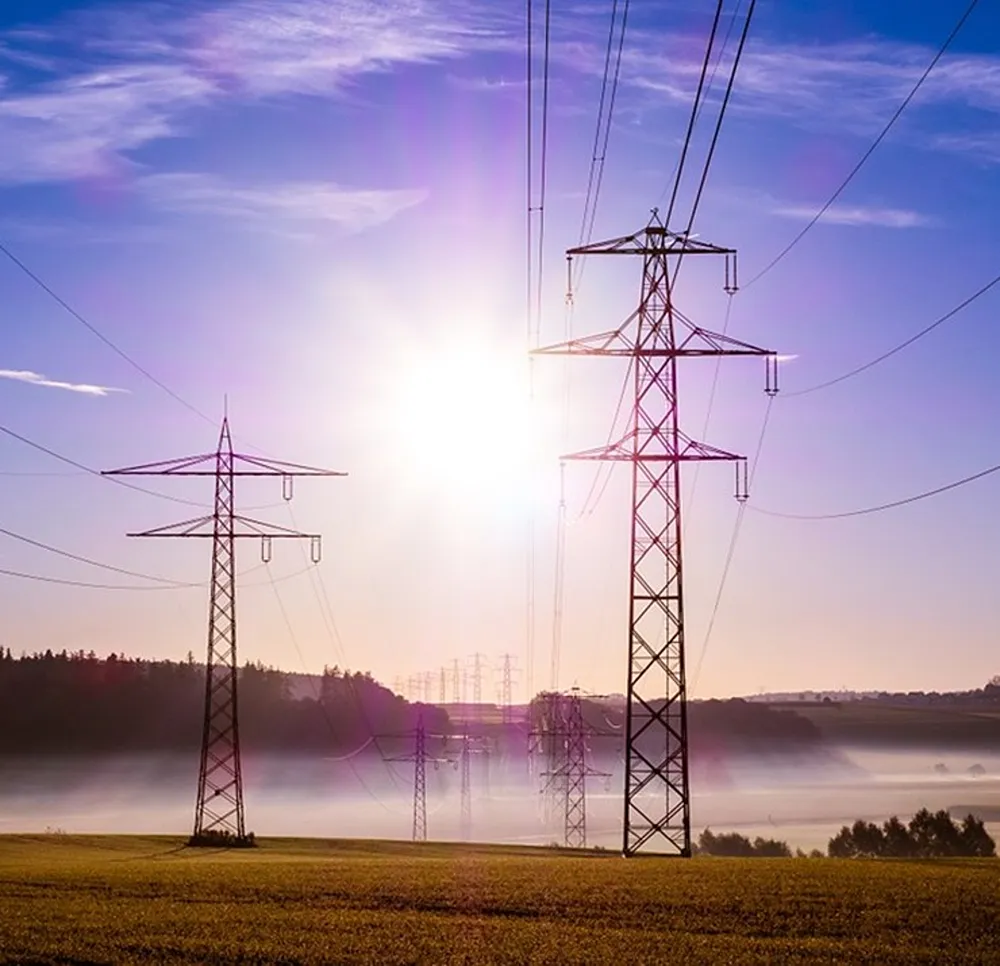Power pylons on a sunny day in a field
