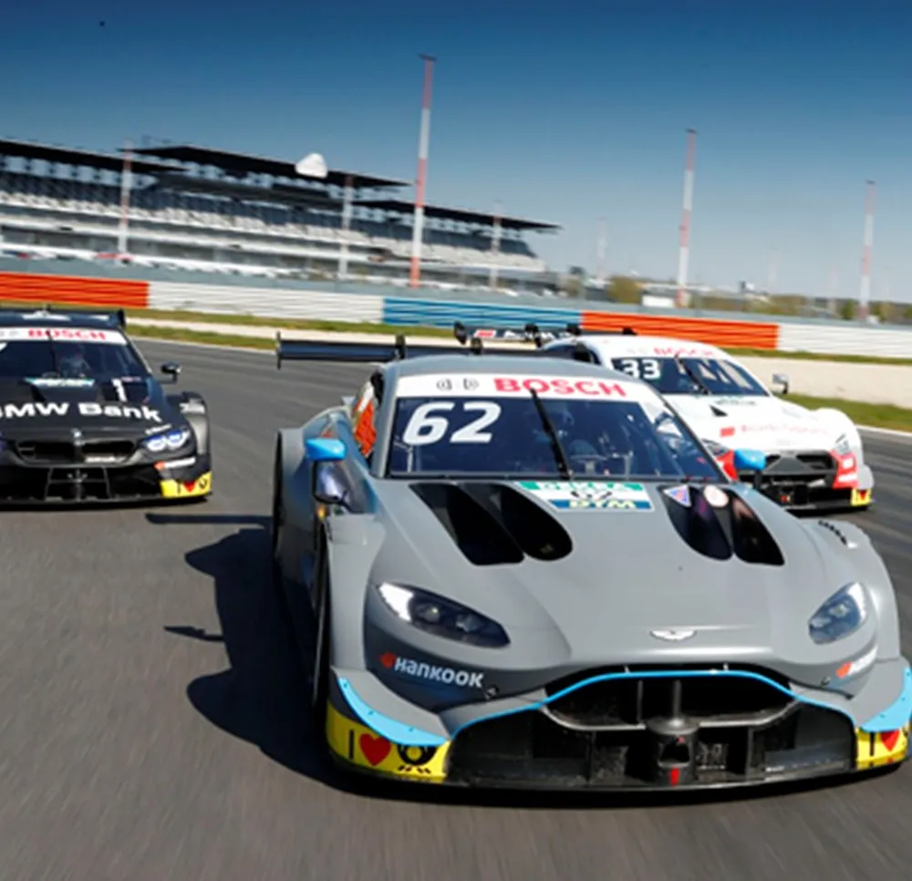 Three racecars racing on a racetrack