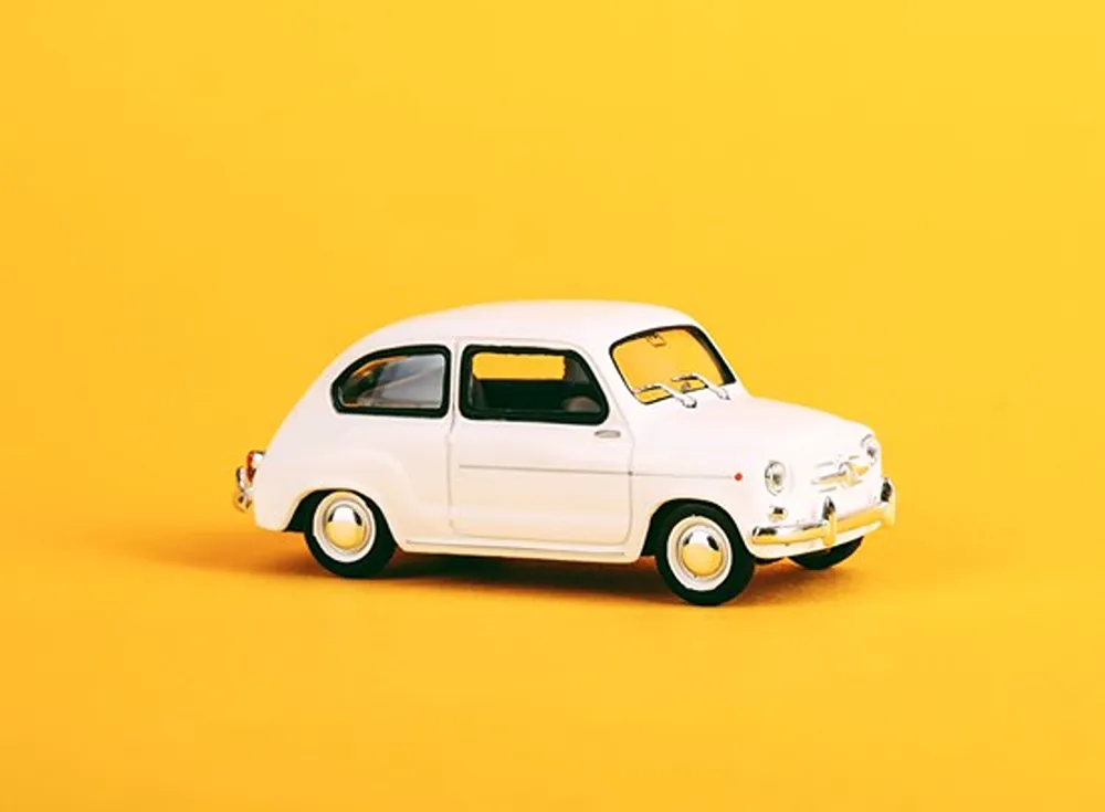 A white car on a yellow background