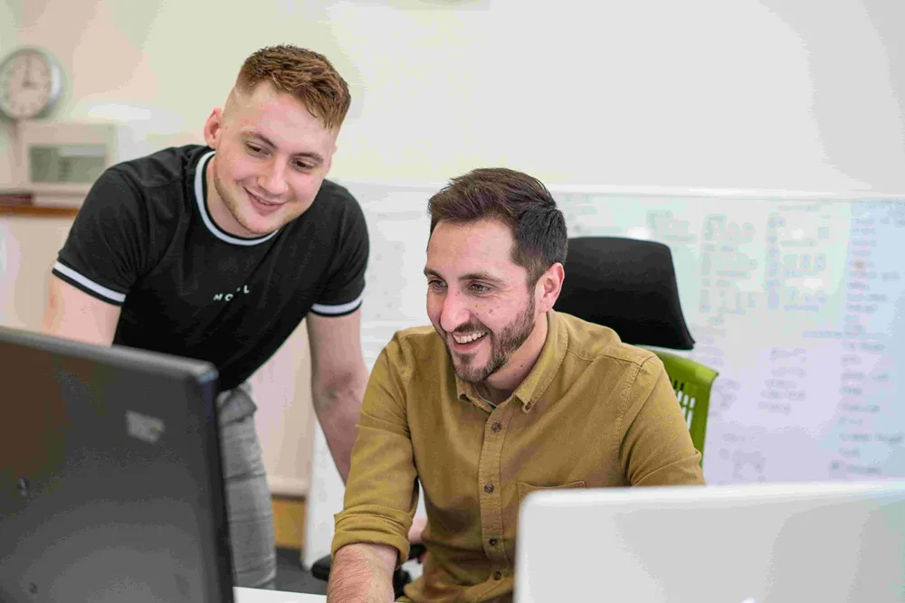 Two Cold Banana employees smiling and working together.
