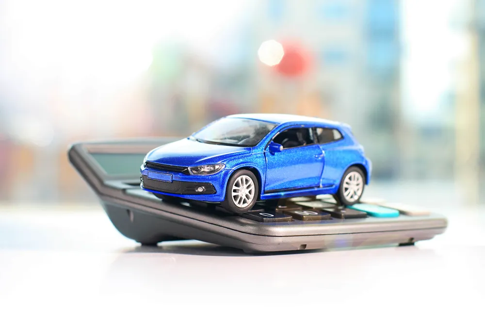 A blue toy car on a calculator.