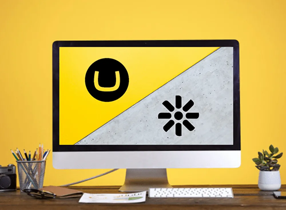 Umbraco and Kentico logos on a desktop monitor in a home office